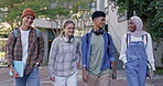 Happy friends, students and walking with books to class for learning, education or social chat at campus. Young people, diversity or learners with group for conversation or discussion at college