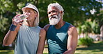 Conversation, drinking water and exercise with interracial old couple in park together for break from training. Fitness, relax or wellness with senior man and woman talking in nature for bonding