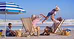 Family, fun and beach chair with child in air with parents, happy and summer holiday by sea. Vacation, playing and airplane game with youth, relax and trip with travel and outdoor with love and care