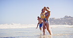 Water, walking and family in vacation, beach and children with parents, happy and travel for bonding. Outdoor, people and kids in holiday, mom and dad with youth, relax and adventure in weekend