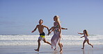 Waves, parents and kids with running on beach, family vacation and bonding by seaside. Playful, mother and father with children for holiday journey, connection and happy with holding hands on ocean
