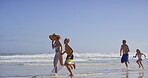 Playful, parents and children with running on beach, family vacation and bonding by seaside. Waves, mother and father with kids for holiday journey, connection and happy with holding hands on ocean