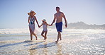 Walking, water and family with holding hands on beach, travel vacation and bonding by seaside. Happy people, mom and dad with girl for holiday adventure, connection and child jump with joy on ocean