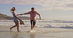 Beach, love and playing in ocean with couple outdoor together for anniversary, honeymoon or romance. Having fun, laughing or smile with man and woman in sea of tropical island paradise for bonding
