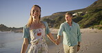 Couple, outdoor and walking by ocean, love and talking on vacation for romance on honeymoon. People, holding hands and laughing on tropical island, support and drag husband by waves on weekend date