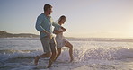 Beach, water splash and couple holding hands for romance, honeymoon and travel for fun, kick and love. Woman, man and sea for date with sunset, adventure or happy bonding and joy on Miami holiday