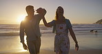 Couple, sunset and dancing at beach, love and holding hands on vacation for romance on honeymoon. People, trust and celebrate anniversary on tropical island, support and movement by waves on date