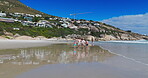 Family, children and holding hands with walking on beach for summer vacation, tropical journey and bonding together. Parents, kids and ocean water with holiday fun, calm morning and travel adventure