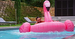 Vacation, relax and man in pool with float, smile and inflatable in water with flamingo at resort. Summer, weekend and happy guy swimming at hotel with adventure, celebration and fun holiday trip