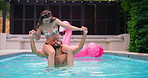 Balance, pool party and couple with fun, splash and bonding at hotel or resort. Swimming, shoulder carry and man with woman, water and laughing for summer event, holiday celebration or adventure