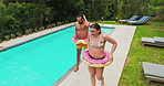 Walking, happy or couple by swimming pool for holiday, summer vacation or weekend break. House backyard, leave or people with inflatable floaters for outdoor travel, hotel or honeymoon in Australia