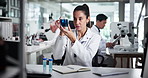 Woman, scientist and beaker with sample at lab for progress report with notes, stats and planning. Person, notebook and test tube with liquid, chemical and medical research for pharmaceutical study