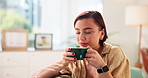 Sofa, woman and relax with coffee for smell, soothing sensation and smile with espresso at home. House, female person and chilling with aroma for warm cappuccino, caffeine and drink in living room