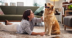 Relax, love and woman with dog in living room in home for bonding, connection or companion. Happy, adoption and female person on floor with golden retriever pet for rubbing animal, pet or puppy.