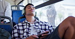 Bus, tired and man with headphones in city for journey, commute and passenger in town. Public transport, travel and fatigued person on vehicle listening to podcast, audio and radio on trip or travel