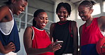 Basketball, sports and women with smartphone, smile and app for fitness training. Happy people, group and athletes in wellness center, cellphone and social media for game, conversation and connection