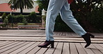 Walking, outdoor and legs of woman with heels, fashion or cool shoes on wooden floor. Ground, person and feet with steps to travel on oak planks in city, park or urban town with footwear for journey