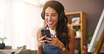 Home, painter and woman with smartphone, headphones and funny with online video. Mature person, apartment and artist in lounge, cellphone and headset with joke, laughing and creativity with break