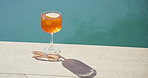 Swimming pool, drink and cocktail with sunglasses for holiday, summer vacation or relax outdoor. Water, alcohol and glass at hotel resort for tourism, travel and luxury with fresh lemon beverage