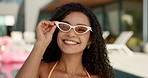 Sunglasses, fashion and face of woman by swimming pool for holiday, vacation and relax at resort. Happy, style and portrait of person in swimsuit outdoors with confidence, pride and smile by water