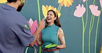 Couple, play and painting with wall art for mural process, creativity and decoration of community project. Man, woman and laughing with artist brush, flower aesthetic and bonding for diy inspiration