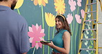 Wall art, friends and painting mural with laugh for creativity, community project and student hobby. Woman, man and people for artist with diy decor, painter and flowers with expression outdoors