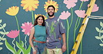 Face, happy and couple with painting on wall for mural art, creativity and decoration of community project. Portrait, people and embracing as artist, flower aesthetic and bonding with diy inspiration