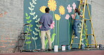 Wall art, collaboration and painting mural with brush for creativity, community project or student hobby. Woman, man and friends for artist with diy decor, painter or flowers with expression outdoors