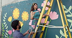 Wall art, team and painting mural with helping for creativity, community project or student hobby. Woman, man and friends for artist people with diy decor, painter or flowers with expression outdoors