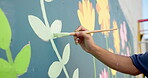 Painting, wall and mural with hand in city for street artist, urban design or environment activist. Flowers, sustainability awareness and creative with person outdoor for earth day, color and culture