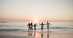 Beach, group and friends with running on vacation, holiday weekend and having fun by sunset in summer. Back, people and water splash in ocean for travel, adventure or freedom  with energy for playful