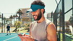 Sports, happy and man with phone on tennis court for social media, online chat and internet. Athlete, fitness and person on smartphone on break relaxing after training, exercise and workout for game