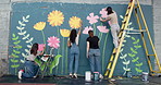 Wall art, women and painting mural with creativity for ladder, community project and student hobby. Girl, friends and people for artist with diy decor, painter and flowers with expression outdoors