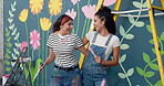 Wall art, friends and women with smile, creative and bonding with complete mural, embrace and laughing. Happiness, face and people with finished artwork, hug and color of flowers or decor for outdoor