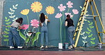 Wall art, people and painting mural with ladder for creativity, community project and student hobby. Girl, friends and women for artist with diy decor, painter and flowers with expression outdoors