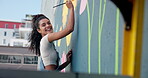 Face, happy and woman for painting mural of creative wall, community project and artistic freedom. Portrait, person and brush with public art, flower design and local culture with therapeutic process