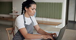 Small business, planning and woman with laptop, cafe and calculation of costs for revenue and typing Serious, entrepreneur and inventory with tech in coffee shop, paperwork and budget for startup