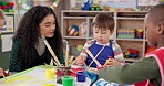 Painting, teacher and children in daycare, art and creativity in classroom, growth and development. Talk, woman and teaching kids in preschool, learning and education for youth with color for artwork