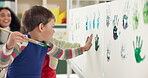 Kids, student and creative with handprint painting of art lesson, identity poster and preschool learning. Children, messy canvas and fun activity, artwork project and color mixing of education memory
