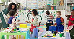 Painting, students and woman with children, teaching and education for group in daycare and learning. Talking, teacher and hands with color for growth, development and art for kids in preschool