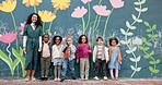 School, mural and teacher with children and wall for friendship, painting or development. Flowers, face and kindergarten street art with group of kids and woman for education, learning and creativity