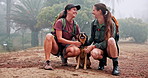 Mountain, hiking and girl friends with dog, smile and outdoor adventure holiday on weekend. Relax, pet and happy women with animal laughing in nature to rest on trekking vacation in morning fog