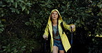 Forest, hiking and woman with stick, raincoat and outdoor adventure holiday on winter weekend. Walking, hill and girl in woods with morning trekking in trees, travel vacation and explore in nature