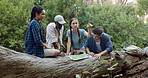 Group, friends and map in nature for hiking, journey or pointing in direction. People, trekking break and chart in woods for navigation, discussion or search for location to explore forest with guide