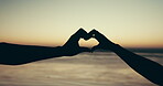 Heart, hands and silhouette at beach for sunset, couple in love with symbol or icon for care, unity and support. Nature, people and travel with gesture for wellness, trust and ocean  for holiday