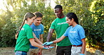 People, volunteer and hands together with community for mission, unity or solidarity in nature. Group, social workers or piling with stack, applause or clapping for eco friendly teamwork or earth day