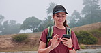 Hiking, happy and woman with phone in nature for direction, navigation and location online. Mountain, typing and person on smartphone for social media on adventure, journey and travel outdoors
