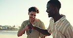 Happy, fist pump and men talking by beach for bonding, conversation and communication. Friends, nature and people relax for hangout, chill and chatting on holiday, vacation and weekend outdoors