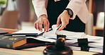 Person, hands and lawyer with paperwork for legal advice, testimonial or statements at office desk. Closeup, employee or attorney with documents for lawsuit, regulations or case notes at law firm