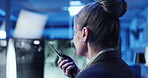 Back, woman and radio in control room for security, protection service and communication at night. Late, mature guard and tech in office for surveillance, contact and building safety update with CCTV